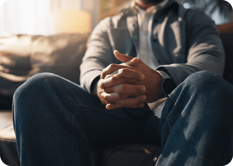 Man sitting with folded hands on couch